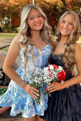 Two smiling teens in 27dress Floral Homecoming Dresses one blue white floral dress and one black ruffle dress holding bouquets