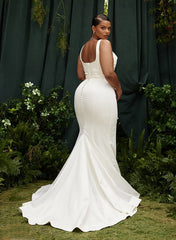 Elegant white satin wedding dress with button back and long train by 27dress surrounded by greenery