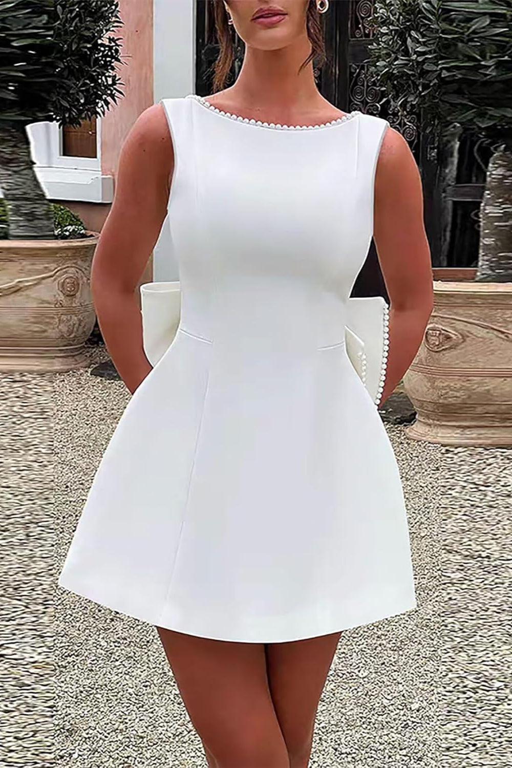 Short white sleeveless A-line bridal dress with a scoop neckline and side pockets.