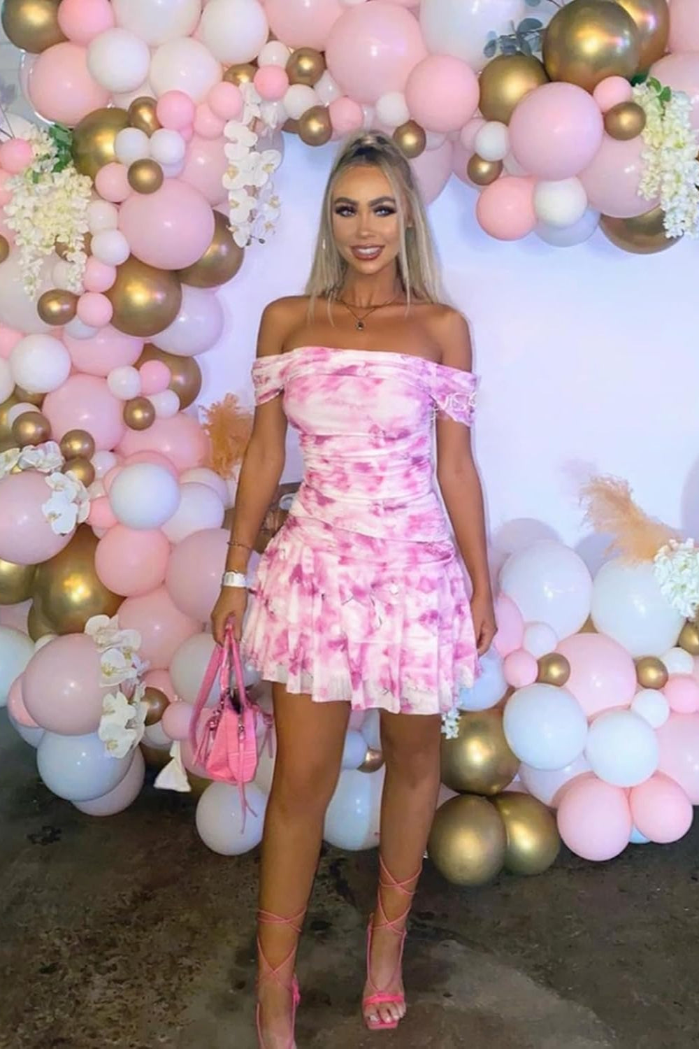 27dress pink off shoulder tie dye mini dress with ruffle skirt and matching heels at pastel balloon arch Homecoming Dresses