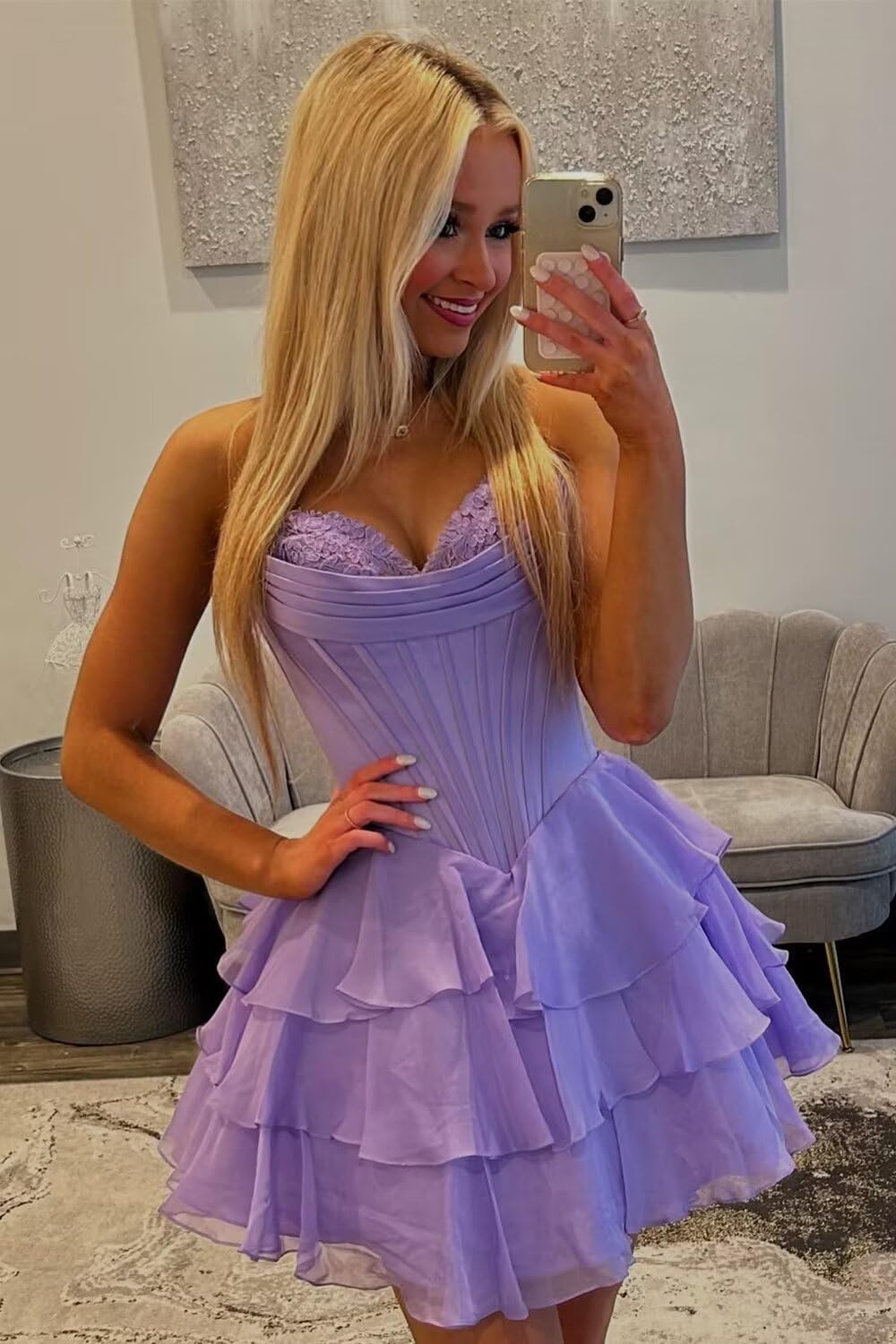 Woman wearing a lavender tiered floral homecoming dress with lace bodice taking a mirror selfie from 27dress